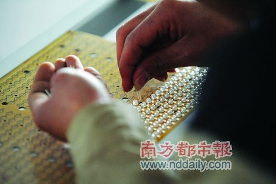 工人忙著安裝用于燈具發(fā)光的LED燈珠，這類工作處于LED燈具生產(chǎn)的最下游。資料圖